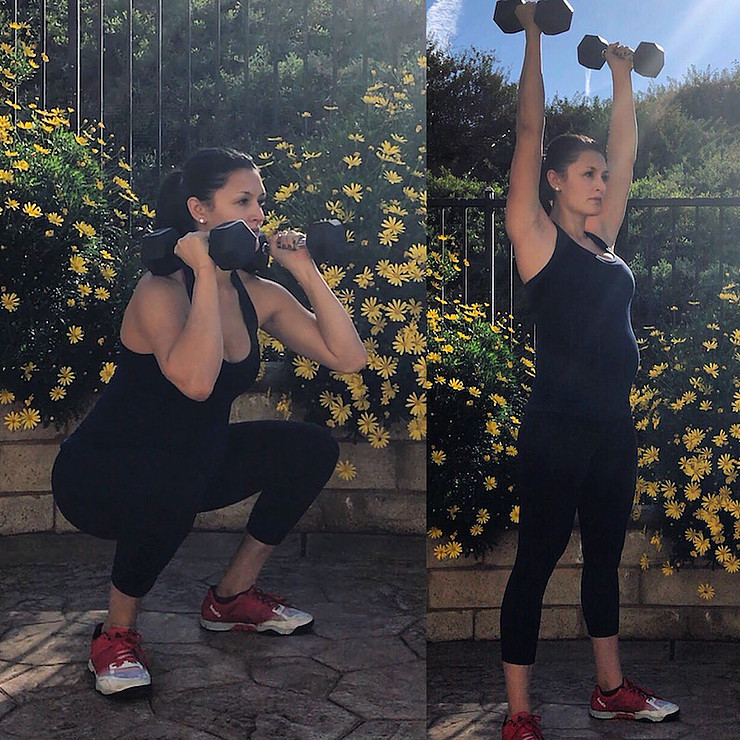 Pregnant woman demonstrating dumbbell thrusters.