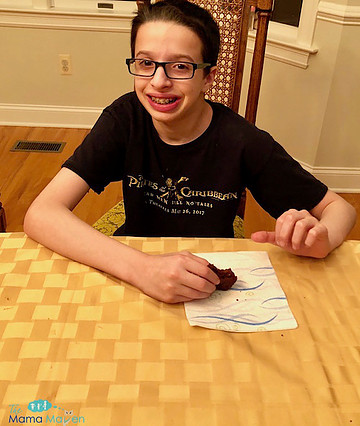 Boy eating a snack at table.