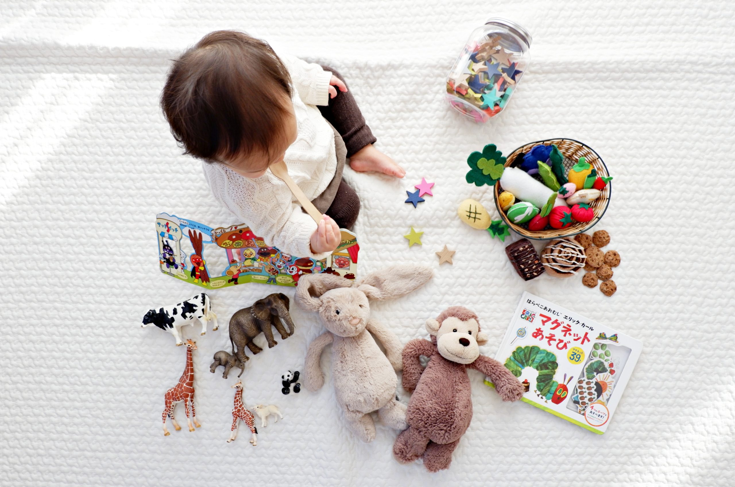 Baby sitting on floor with toys.